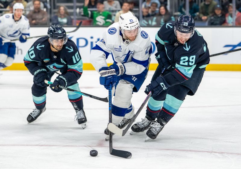 Mar 17, 2026; Seattle, Washington, USA; Tampa Bay Lightning forward Brayden Point (21) skates against Seattle Kraken forward Matty Beniers (10) and defenseman Vince Dunn (29) during the third period at Climate Pledge Arena. Mandatory Credit: Stephen Brashear-Imagn Images