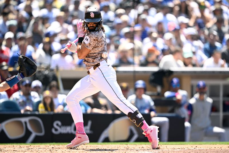 May 12, 2024; San Diego, California, USA; San Diego Padres right fielder Fernando Tatis Jr. (23) is hit by a pitch during the fourth inning against the Los Angeles Dodgers at Petco Park. Mandatory Credit: Orlando Ramirez-USA TODAY Sports