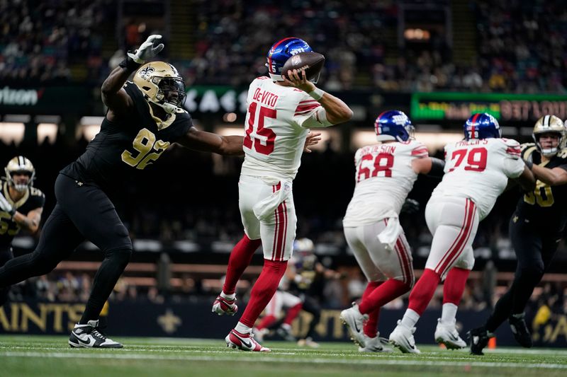 New York Giants quarterback Tommy DeVito (15) passes under pressure from New Orleans Saints defensive end Tanoh Kpassagnon (92) in the second half of an NFL football game in New Orleans, Sunday, Dec. 17, 2023. The Saints won 24-6. (AP Photo/Gerald Herbert)