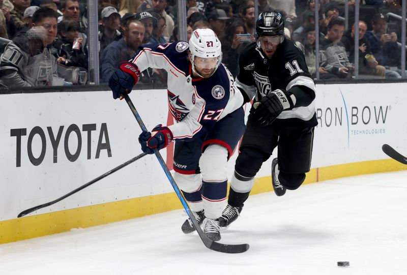 Nov 9, 2024; Los Angeles, California, USA; Columbus Blue Jackets center Zachary Aston-Reese (27) and Los Angeles Kings center Anze Kopitar (11) chase a loose puck during the third period at Crypto.com Arena. Mandatory Credit: Jason Parkhurst-Imagn Images