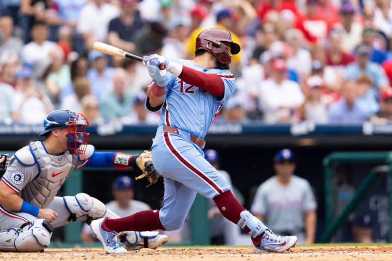 May 23, 2024; Philadelphia, Pennsylvania, USA; Philadelphia Phillies designated hitter Kyle Schwarber (12) hits an RBI single during the fourth inning against the Texas Rangers at Citizens Bank Park. Mandatory Credit: Bill Streicher-USA TODAY Sports