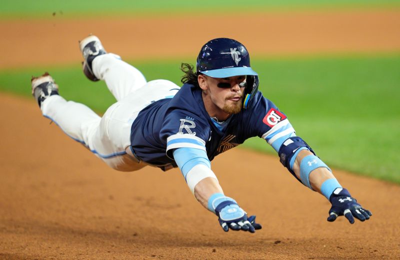 Jun 7, 2024; Kansas City, Missouri, USA; Kansas City Royals shortstop Bobby Witt Jr. (7) slides into third base for a triple during the ninth inning against the Seattle Mariners at Kauffman Stadium. Mandatory Credit: Jay Biggerstaff-USA TODAY Sports