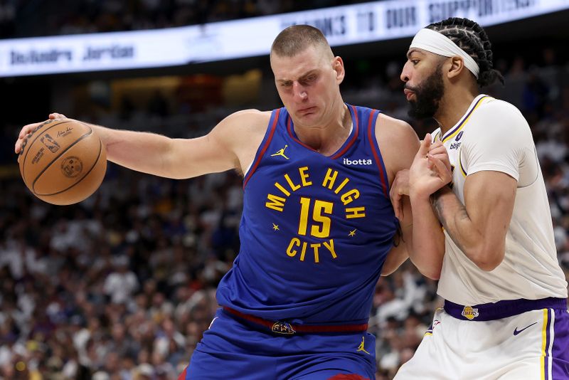 DENVER, COLORADO - APRIL 20: Nikola Jokic #15 of the Denver Nuggets drives against Anthony Davis #3 of the Los Angeles Lakers in the third quarter during game one of the Western Conference First Round Playoffs at Ball Arena on April 20, 2024 in Denver, Colorado.  NOTE TO USER: User expressly acknowledges and agrees that, by downloading and or using this photograph, User is consenting to the terms and conditions of the Getty Images License Agreement. (Photo by Matthew Stockman/Getty Images)