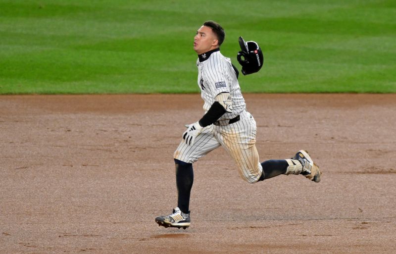 Oct 29, 2024; New York, New York, USA; New York Yankees shortstop Anthony Volpe (11) doubles during the eighth inning against the Los Angeles Dodgers in game four of the 2024 MLB World Series at Yankee Stadium.  Mandatory Credit: John Jones-Imagn Images