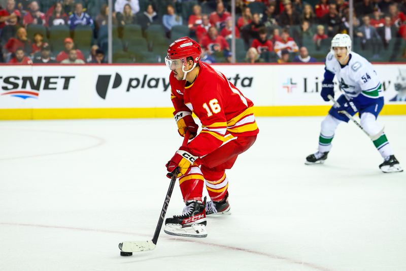 Oct 1, 2025; Calgary, Alberta, CAN; Calgary Flames center Morgan Frost (16) controls the puck against the Vancouver Canucks during the second period at Scotiabank Saddledome. Mandatory Credit: Sergei Belski-Imagn Images