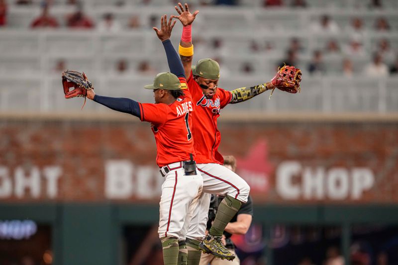 May 19, 2023; Cumberland, Georgia, USA; Atlanta Braves second baseman Ozzie Albies (1) and right fielder Ronald Acuna Jr. (13) react after defeating the Seattle Mariners at Truist Park. Mandatory Credit: Dale Zanine-USA TODAY Sports