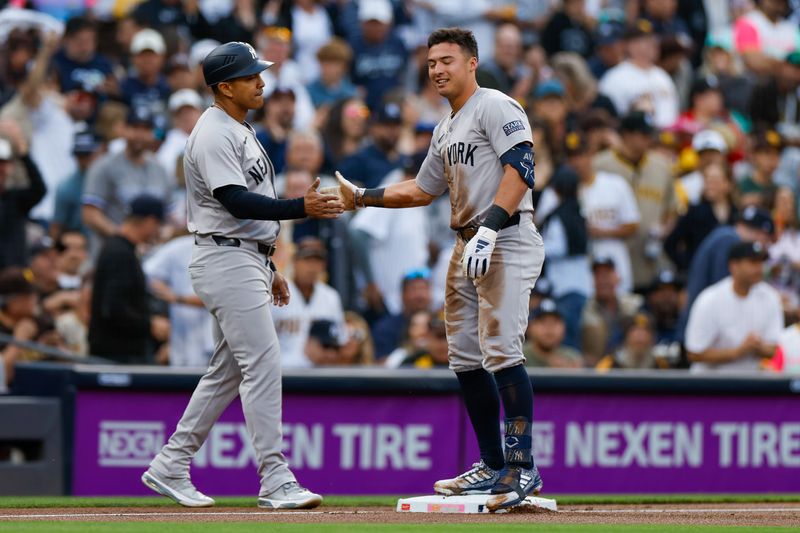 May 24, 2024; San Diego, California, USA;  New York Yankees shortstop Anthony Volpe (11) celebrates with New York Yankees third base coach Luis Rojas (67) after hitting a lead off triple in the first inning against the San Diego Padres at Petco Park. Mandatory Credit: David Frerker-USA TODAY Sports