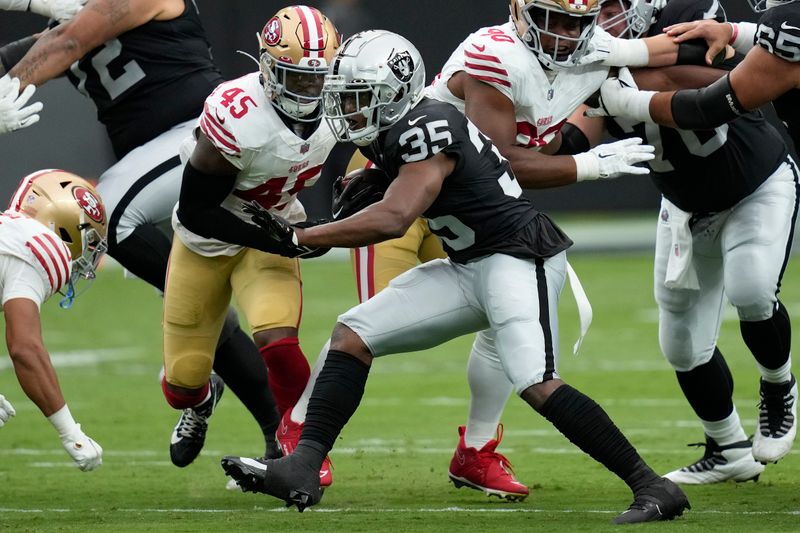 Las Vegas Raiders running back Zamir White (35) runs the ball as San Francisco 49ers linebacker Demetrius Flannigan-Fowles (45) pursues during the first half of an NFL preseason football game, Sunday, Aug. 13, 2023, in Las Vegas. (AP Photo/John Locher)