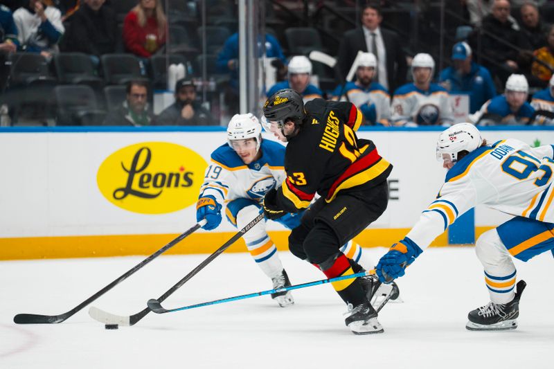 Dec 11, 2025; Vancouver, British Columbia, CAN; Vancouver Canucks defenseman Quinn Hughes (43) drives between Buffalo Sabres forward Peyton Krebs (19) and forward Josh Doan (91) in the first period at Rogers Arena. Mandatory Credit: Bob Frid-Imagn Images