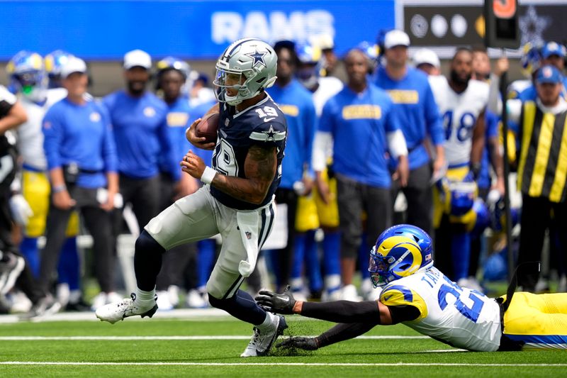 Dallas Cowboys quarterback Trey Lance (19) escapes pressure from Los Angeles Rams safety Jason Taylor II during the first half of a preseason NFL football game, Sunday, Aug. 11, 2024, in Inglewood, Calif. (AP Photo/Ryan Sun)