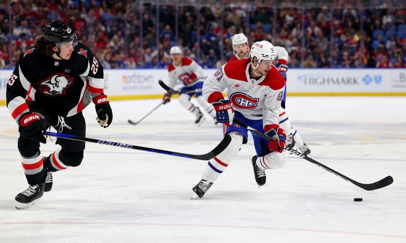 Dec 9, 2023; Buffalo, New York, USA;  Montreal Canadiens center Sean Monahan (91) carries the puck up ice as Buffalo Sabres defenseman Owen Power (25) defends during the first period at KeyBank Center. Mandatory Credit: Timothy T. Ludwig-USA TODAY Sports