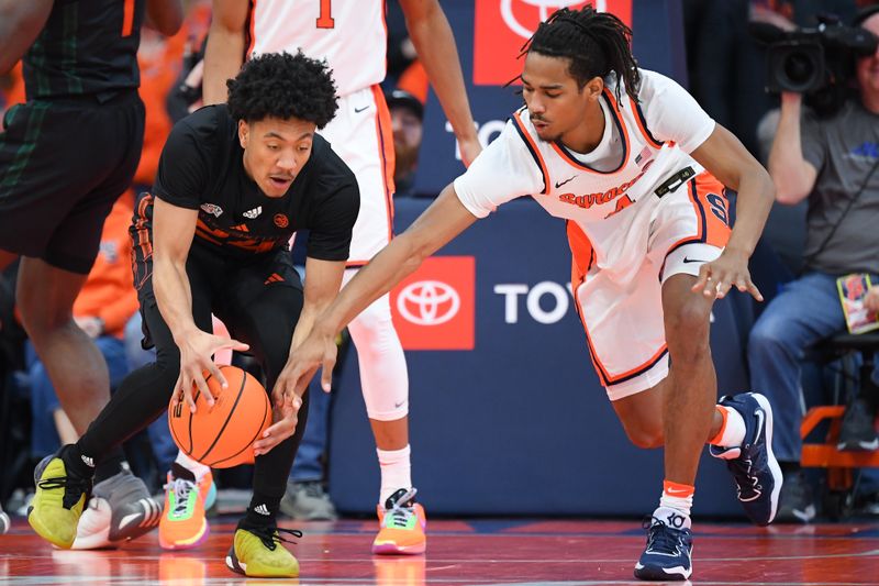 Jan 20, 2024; Syracuse, New York, USA; Miami (Fl) Hurricanes guard Nijel Pack (24) and Syracuse Orange forward Chris Bell (4) battle for a loose ball during the second half at the JMA Wireless Dome. Mandatory Credit: Rich Barnes-USA TODAY Sports