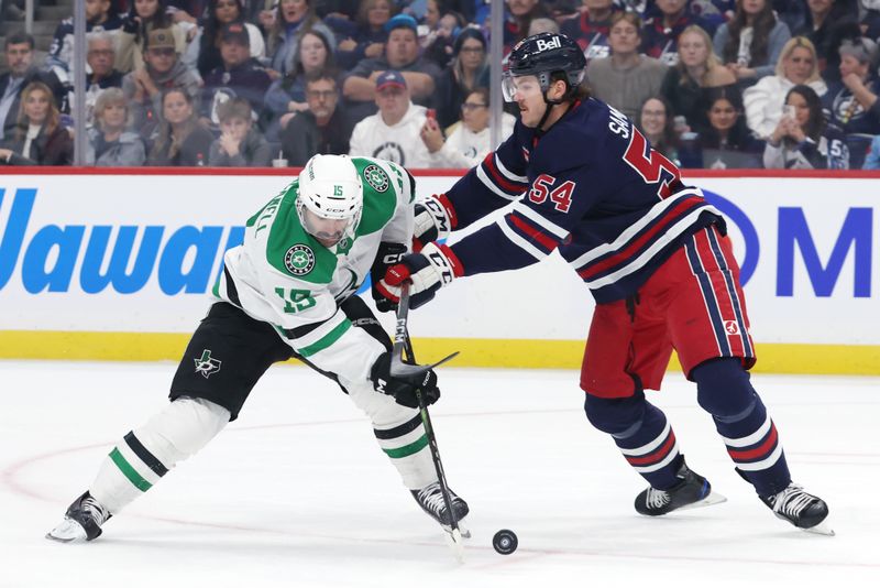 Nov 9, 2024; Winnipeg, Manitoba, CAN; Dallas Stars center Colin Blackwell (15) is checked by Winnipeg Jets defenseman Dylan Samberg (54) in the first period at Canada Life Centre. Mandatory Credit: James Carey Lauder-Imagn Images