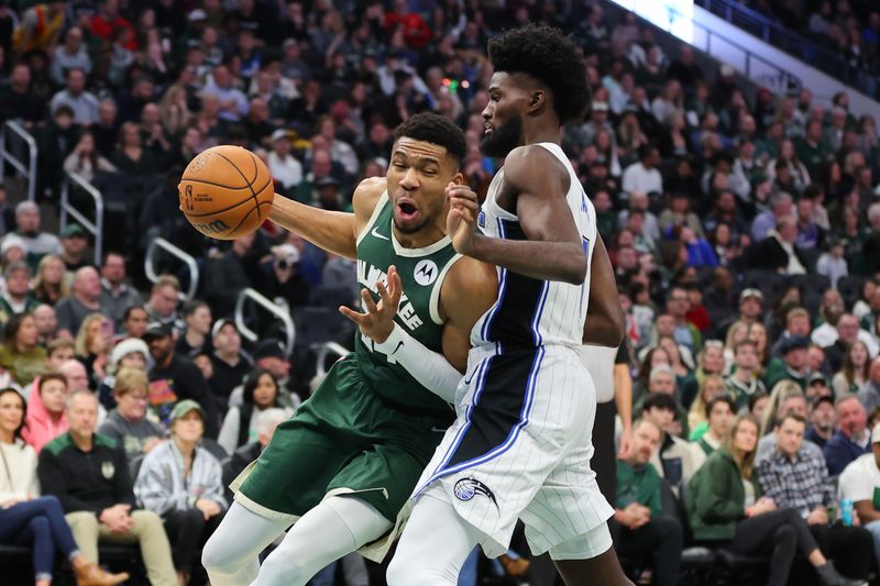 MILWAUKEE, WISCONSIN - DECEMBER 21: Giannis Antetokounmpo #34 of the Milwaukee Bucks is defended by Jonathan Isaac #1 of the Orlando Magic during a game at Fiserv Forum on December 21, 2023 in Milwaukee, Wisconsin. NOTE TO USER: User expressly acknowledges and agrees that, by downloading and or using this photograph, User is consenting to the terms and conditions of the Getty Images License Agreement. (Photo by Stacy Revere/Getty Images)