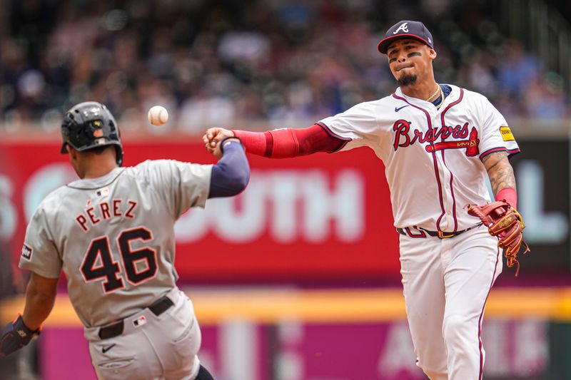 Jun 19, 2024; Cumberland, Georgia, USA; Atlanta Braves shortstop Orlando Arcia (11) turns a double play over top of Detroit Tigers right fielder Wenceel Perez (46) during the third inning at Truist Park. Mandatory Credit: Dale Zanine-USA TODAY Sports