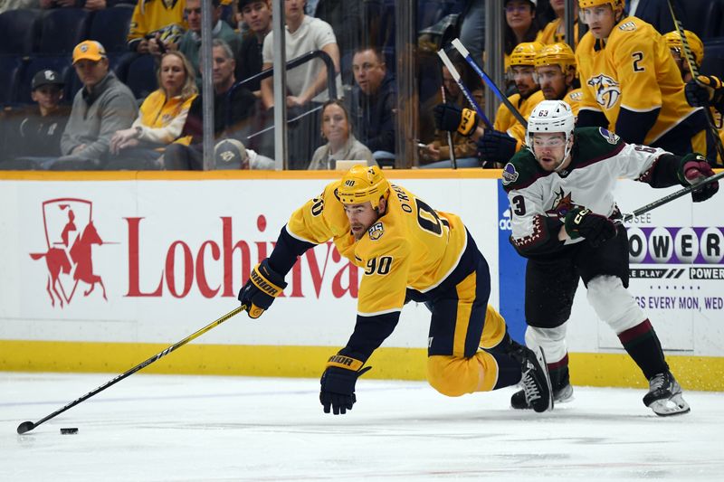 Feb 10, 2024; Nashville, Tennessee, USA; Nashville Predators center Ryan O'Reilly (90) reaches for the puck against Arizona Coyotes left wing Matias Maccelli (63) during the first period at Bridgestone Arena. Mandatory Credit: Christopher Hanewinckel-USA TODAY Sports