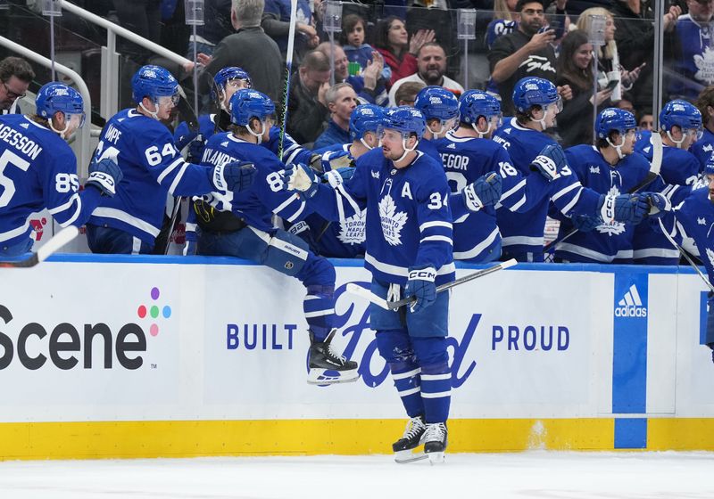 Feb 15, 2024; Toronto, Ontario, CAN; Toronto Maple Leafs center Auston Matthews (34) celebrates with teammates after scoring his first goal against the Philadelphia Flyers during the second period at Scotiabank Arena. Mandatory Credit: Nick Turchiaro-USA TODAY Sports