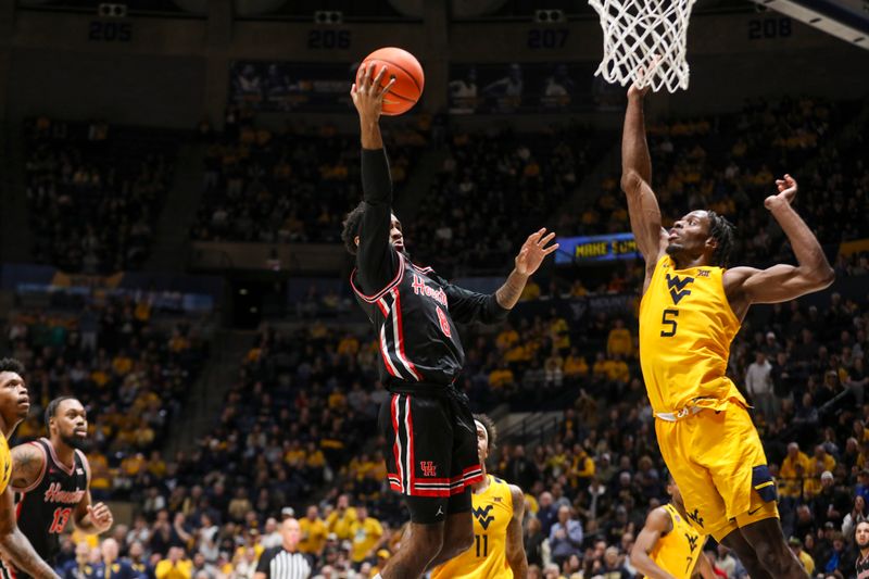 Jan 29, 2025; Morgantown, West Virginia, USA; Houston Cougars guard Mylik Wilson (8) shoots in the lane over West Virginia Mountaineers guard Toby Okani (5) during the second half at WVU Coliseum. Mandatory Credit: Ben Queen-Imagn Images