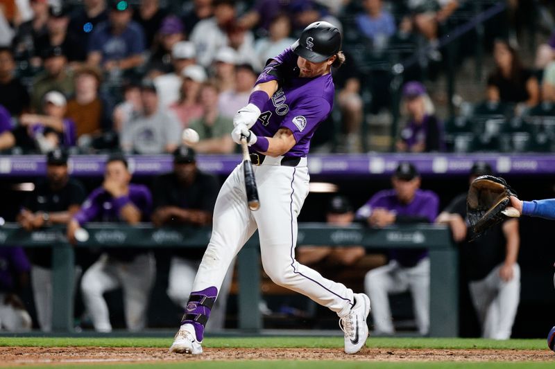 Jun 17, 2024; Denver, Colorado, USA; Colorado Rockies right fielder Michael Toglia (4) hits a double in the ninth inning against the Los Angeles Dodgers at Coors Field. Mandatory Credit: Isaiah J. Downing-USA TODAY Sports