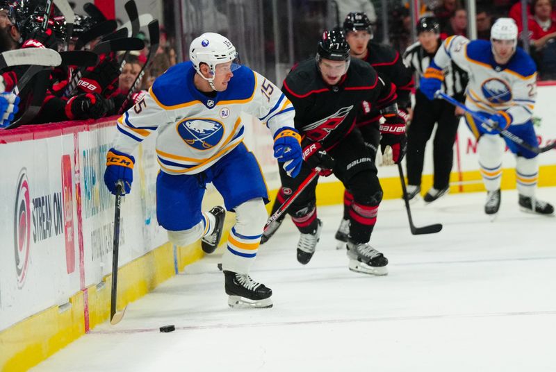 Dec 2, 2023; Raleigh, North Carolina, USA; Buffalo Sabres left wing Brandon Biro (15) skates with the puck away from Carolina Hurricanes defenseman Dmitry Orlov (7) during the second period PNC Arena. Mandatory Credit: James Guillory-USA TODAY Sports