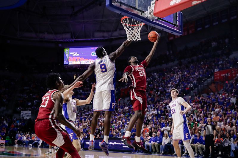 Feb 28, 2026; Gainesville, Florida, USA; Arkansas Razorbacks wing Billy Richmond III (24) goes to the basket over Florida Gators center Rueben Chinyelu (9) during the first half at Exactech Arena at the Stephen C. O'Connell Center. Mandatory Credit: Travis Register-Imagn Images