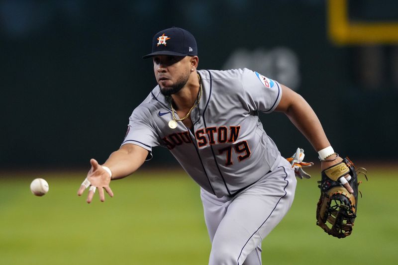 Sep 30, 2023; Phoenix, Arizona, USA; Houston Astros first baseman Jose Abreu (79) flips the ball against the Arizona Diamondbacks during the first inning at Chase Field. Mandatory Credit: Joe Camporeale-USA TODAY Sports