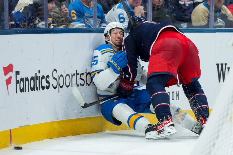Nov 1, 2025; Columbus, Ohio, USA;  Columbus Blue Jackets defenseman Ivan Provorov (9) hits St. Louis Blues right wing Jordan Kyrou (25) along the boards in the third period at Nationwide Arena. Mandatory Credit: Aaron Doster-Imagn Images