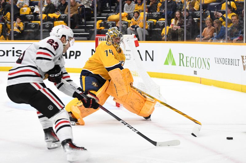 Jan 2, 2024; Nashville, Tennessee, USA; Nashville Predators goaltender Juuse Saros (74) plays the puck before pressure from Chicago Blackhawks center Philipp Kurashev (23) during the second period at Bridgestone Arena. Mandatory Credit: Christopher Hanewinckel-USA TODAY Sports