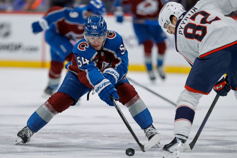 Jan 10, 2026; Denver, Colorado, USA; Colorado Avalanche center Gavin Brindley (54) knocks the puck away from Columbus Blue Jackets left wing Mikael Pyyhtia (82) in the second period at Ball Arena. Mandatory Credit: Isaiah J. Downing-Imagn Images