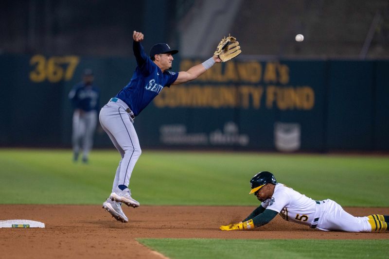 Sep 19, 2023; Oakland, California, USA; Oakland Athletics left fielder Tony Kemp (5) is caught stealing by Seattle Mariners third baseman Josh Rojas (4) during the third inning at Oakland-Alameda County Coliseum. Mandatory Credit: Neville E. Guard-USA TODAY Sports