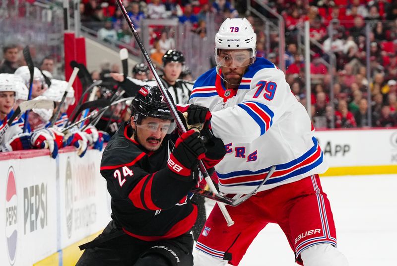 Nov 27, 2024; Raleigh, North Carolina, USA;  New York Rangers defenseman K'Andre Miller (79) go after the puck Carolina Hurricanes center Seth Jarvis (24) during the first period at Lenovo Center. Mandatory Credit: James Guillory-Imagn Images