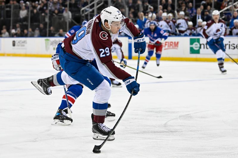 Feb 5, 2024; New York, New York, USA;  Colorado Avalanche center Nathan MacKinnon (29) attempts a shot against the New York Rangers during the third period at Madison Square Garden. Mandatory Credit: Dennis Schneidler-USA TODAY Sports