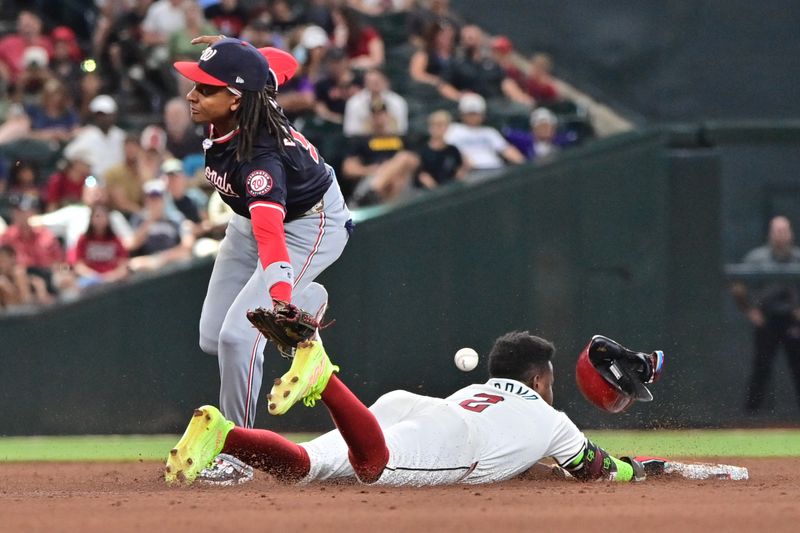 Jul 31, 2024; Phoenix, Arizona, USA; Arizona Diamondbacks shortstop Geraldo Perdomo (2) steals second base against Washington Nationals shortstop CJ Abrams (5) in the sixth inning at Chase Field. Mandatory Credit: Matt Kartozian-USA TODAY Sports