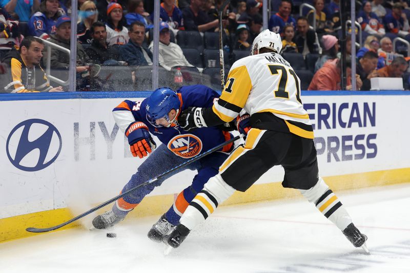 Nov 5, 2024; Elmont, New York, USA; New York Islanders defenseman Scott Mayfield (24) and Pittsburgh Penguins center Evgeni Malkin (71) fight for the puck during the first period at UBS Arena. Mandatory Credit: Brad Penner-Imagn Images