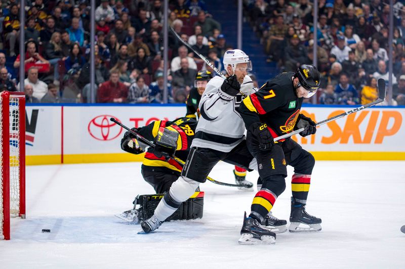 Mar 25, 2024; Vancouver, British Columbia, CAN; Los Angeles Kings forward Trevor Lewis (61) battles with Vancouver Canucks defenseman Carson Soucy (7) as the shot from forward Blake Lizotte (not pictured) beats goalie Casey DeSmith (29) in the second period  at Rogers Arena. Mandatory Credit: Bob Frid-USA TODAY Sports