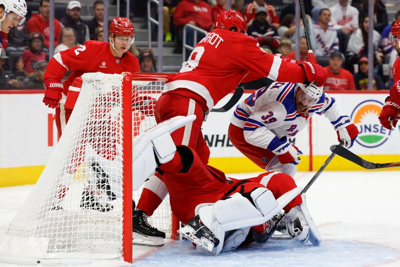 Oct 17, 2024; Detroit, Michigan, USA;  Detroit Red Wings goaltender Alex Lyon (34) makes a save on New York Rangers center Sam Carrick (39) in the third period at Little Caesars Arena. Mandatory Credit: Rick Osentoski-Imagn Images