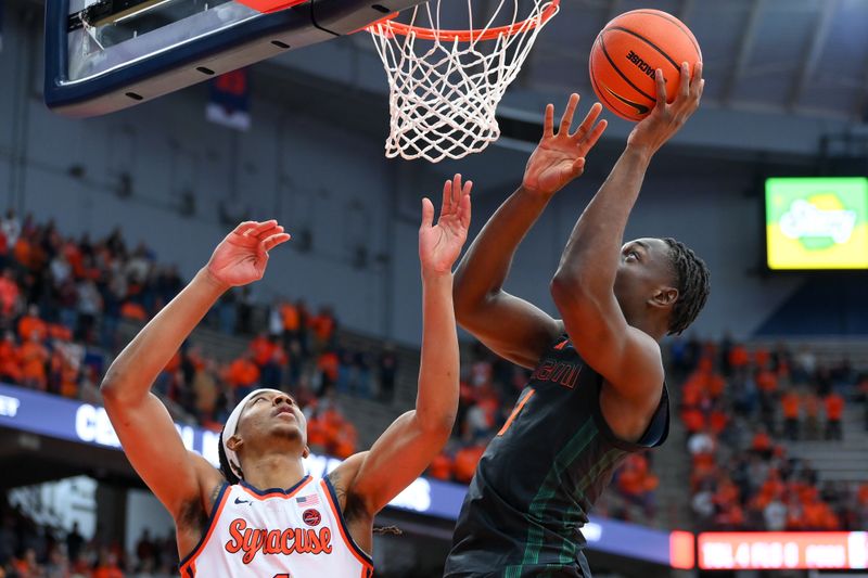 Jan 20, 2024; Syracuse, New York, USA; Miami (Fl) Hurricanes center Michael Nwoko (1) shoots the ball as Syracuse Orange forward Maliq Brown (1) defends during the first half at the JMA Wireless Dome. Mandatory Credit: Rich Barnes-USA TODAY Sports