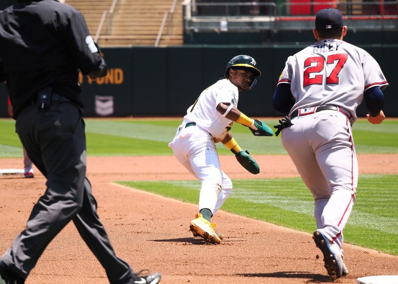 May 31, 2023; Oakland, California, USA; Oakland Athletics center fielder Esteury Ruiz (1) is caught stealing third base by Atlanta Braves third baseman Austin Riley (27) during the first inning at Oakland-Alameda County Coliseum. Mandatory Credit: Kelley L Cox-USA TODAY Sports