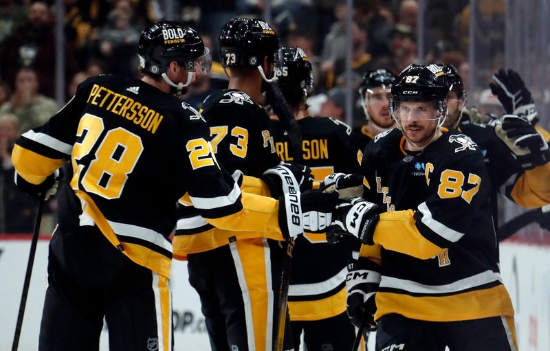 Apr 11, 2024; Pittsburgh, Pennsylvania, USA; Pittsburgh Penguins defenseman Marcus Pettersson (28) and defenseman Pierre-Olivier Joseph (73) congratulate center Sidney Crosby (87) on his goal against the Detroit Red Wings during the second period at PPG Paints Arena. Mandatory Credit: Charles LeClaire-USA TODAY Sports