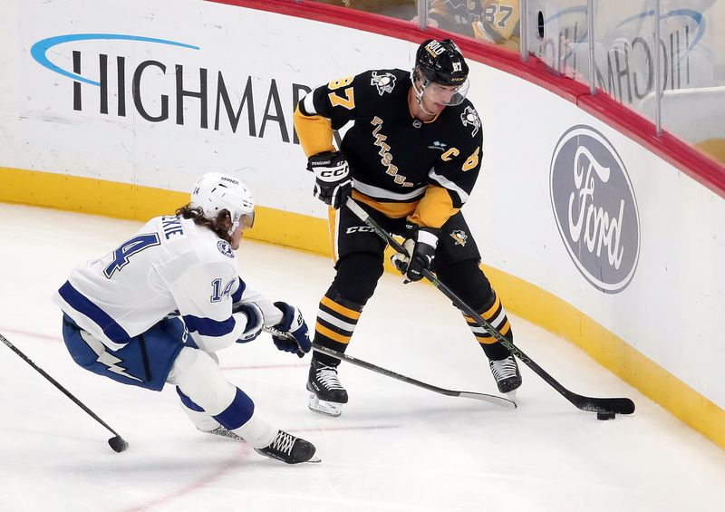 Nov 19, 2024; Pittsburgh, Pennsylvania, USA; Pittsburgh Penguins center Sidney Crosby (87) handles the puck against Tampa Bay Lightning center Conor Geekie (14) during the second period at PPG Paints Arena. Mandatory Credit: Charles LeClaire-Imagn Images