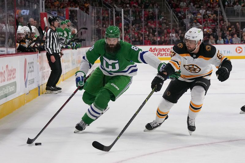 Mar 26, 2023; Raleigh, North Carolina, USA;  Carolina Hurricanes defenseman Brent Burns (8) skates with the puck against Boston Bruins defenseman Jakub Zboril (67) during the first period at PNC Arena. Mandatory Credit: James Guillory-USA TODAY Sports