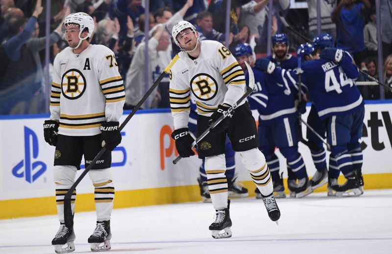 May 2, 2024; Toronto, Ontario, CAN;   Boston Bruins defenseman Charlie McAvoy (73) and forward John Beecher (19) react as Toronto Maple Leafs players celebrate a goal by William Nylander (88) in the second period in game six of the first round of the 2024 Stanley Cup Playoffs at Scotiabank Arena. Mandatory Credit: Dan Hamilton-USA TODAY Sports