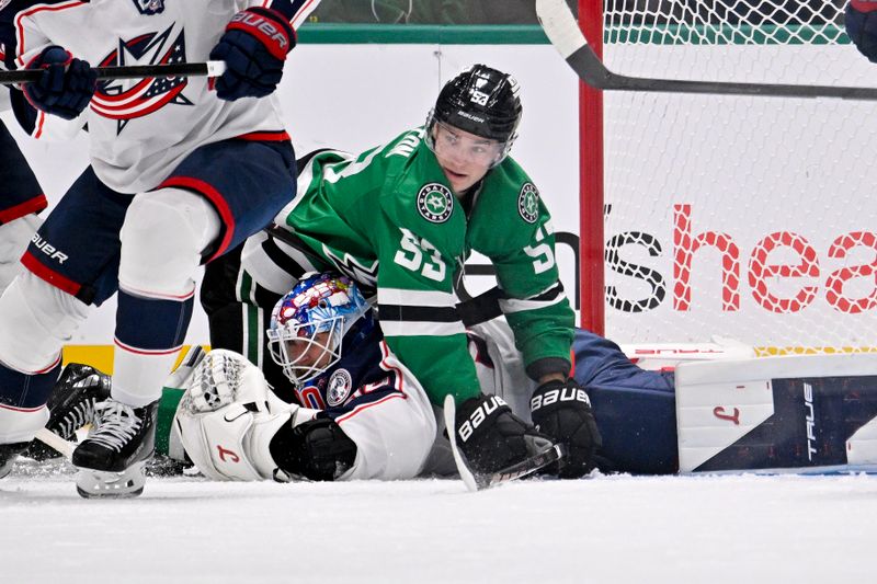 Oct 21, 2025; Dallas, Texas, USA; Dallas Stars center Wyatt Johnston (53) lands on top of Columbus Blue Jackets goaltender Elvis Merzlikins (90) during the first period at the American Airlines Center. Mandatory Credit: Jerome Miron-Imagn Images