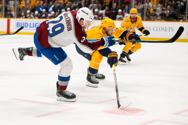 Nov 2, 2024; Nashville, Tennessee, USA;  Colorado Avalanche center Nathan MacKinnon (29) takes a shot on goal against the Nashville Predators during the second period at Bridgestone Arena. Mandatory Credit: Steve Roberts-Imagn Images