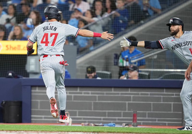 May 11, 2024; Toronto, Ontario, CAN; Minnesota Twins second baseman Edouard Julien (47) scores a run and celebrates with left fielder Alex Kirilloff (19) against the Toronto Blue Jays during the first inning at Rogers Centre. Mandatory Credit: Nick Turchiaro-USA TODAY Sports