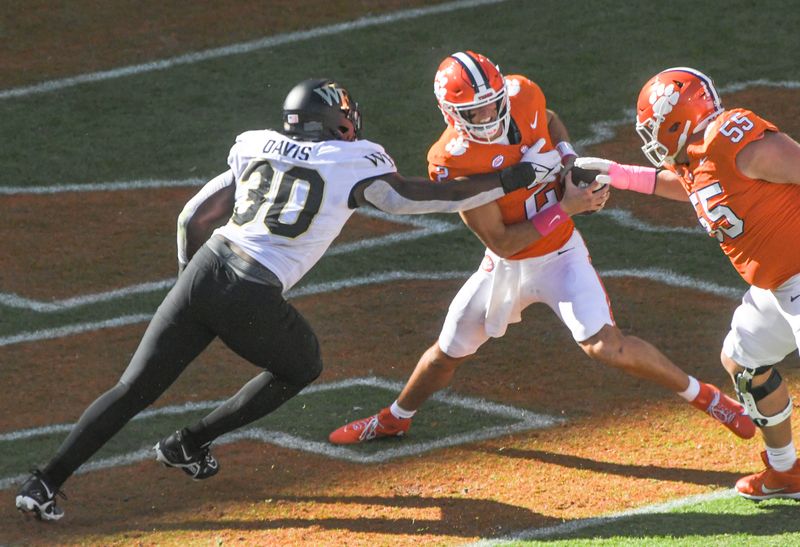 Oct 7, 2023; Clemson, South Carolina, USA; Clemson quarterback Cade Klubnik (2) avoids being sacked in the end zone by Wake Forest defensive lineman Jasheen Davis (30) during the first quarter  at Memorial Stadium. Mandatory Credit: Ken Ruinard-USA TODAY Sports