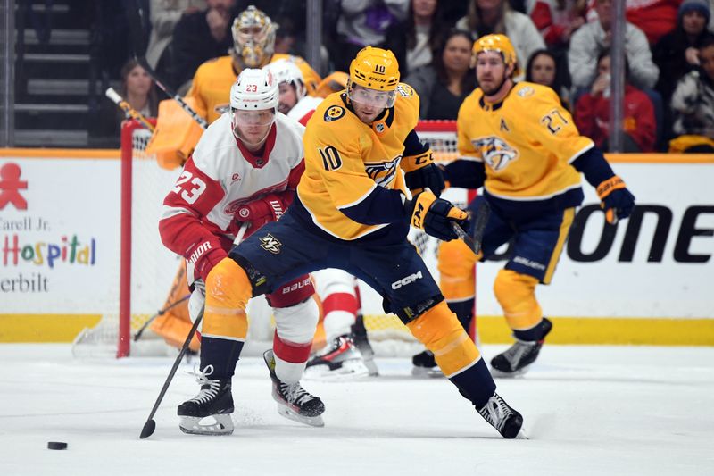 Mar 23, 2024; Nashville, Tennessee, USA; Nashville Predators center Colton Sissons (10) defends against Detroit Red Wings left wing Lucas Raymond (23) during the third period at Bridgestone Arena. Mandatory Credit: Christopher Hanewinckel-USA TODAY Sports