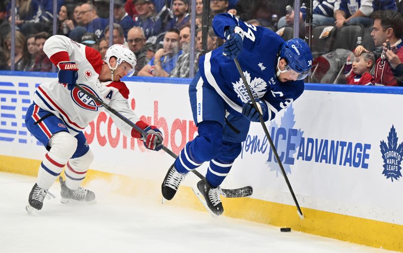 Apr 12, 2025; Toronto, Ontario, CAN;  Toronto Maple Leafs forward Auston Matthews (34) battles for the puck with Montreal Canadiens defenseman Mike Matheson (8) in the first period at Scotiabank Arena. Mandatory Credit: Dan Hamilton-Imagn Images