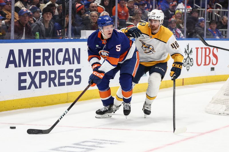 Jan 31, 2026; Elmont, New York, USA;  New York Islanders left wing Emil Heineman (51) and Nashville Predators defenseman Nick Perbix (48) battle for control of the puck in the second period at UBS Arena. Mandatory Credit: Wendell Cruz-Imagn Images