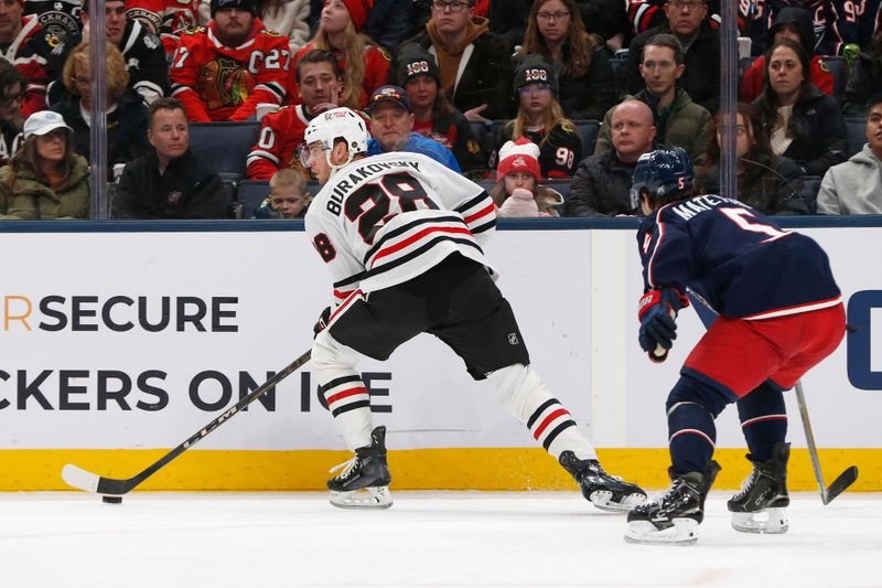 Feb 4, 2026; Columbus, Ohio, USA; Chicago Blackhawks left wing Andre Burakovsky (28) controls the puck as Columbus Blue Jackets defenseman Denton Mateychuk (5) defends during the first period at Nationwide Arena. Mandatory Credit: Russell LaBounty-Imagn Images